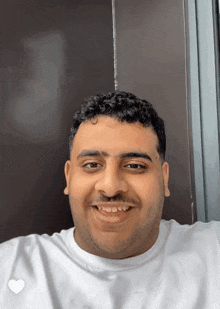 a man with curly hair and a mustache is smiling
