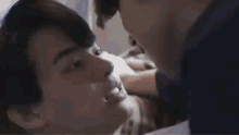 two men are kissing each other on a couch .