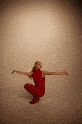 a woman in a red dress with her arms outstretched