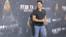 a man is standing in front of a star trek discovery poster