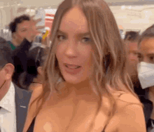 a woman wearing a mask is standing in a crowd .