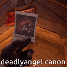 a person is holding a picture with the caption deadlyangel canon
