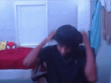 a man is sitting in a chair with his hands on his head in a room .