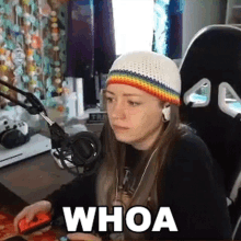 a woman wearing a hat and headphones is playing a video game and the word whoa is on the screen