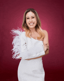 a woman in a white dress with feathers on her sleeves