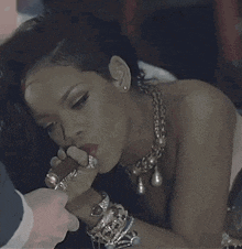 a woman is smoking a cigar in a dark room while a man is holding a lighter .