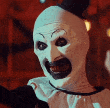 a creepy clown with a top hat on his head