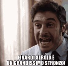 a man in a suit and tie says einardi sergio e un grandissimo stronzo !