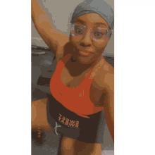 a woman wearing glasses and a red tank top is kneeling down