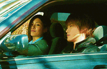 a man and a woman are sitting in a car and looking out the window
