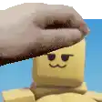 a person is putting a beret on a lego man 's head .