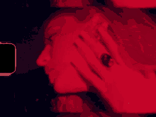 a close up of a woman 's face with a ring on her finger