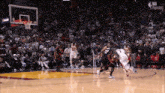 a group of basketball players are playing a game of basketball on a court .