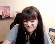 a woman with a cat face painted on her face is wearing headphones