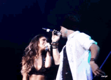 a man and a woman singing into microphones on a stage with a watermark that says rbd.gif