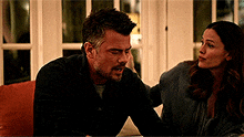 a man and a woman are sitting next to each other on a couch .