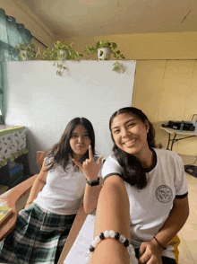 two girls are posing for a picture and one of them is wearing a shirt that says ' pacific ' on it