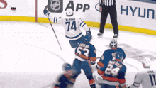 a hockey player with the number 74 on his jersey stands on the ice
