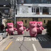 a group of pink teddy bears are walking down a street in front of a sign that says royal salon