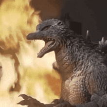 a statue of a monster is standing in front of a fire .