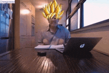 a man sitting at a table with a laptop and a picture of goku on his head with the word unregistered below it