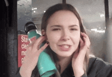 a woman covering her ears next to a sign that says " stay clear "