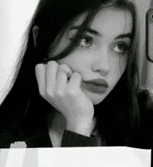 a black and white photo of a woman with a ring on her finger that says evil
