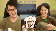 a man and a woman are sitting in front of a screen that says #dechart games