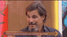 a man with a beard is on a television screen with the words o tempo não para