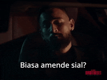 a man with a beard is smoking a cigarette and the words biasa amende sial below him