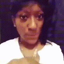 a woman in a white shirt is looking at the camera