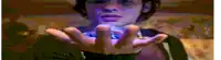 a young boy is holding a small object in his hand .