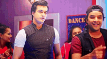 a group of people are standing in front of a sign that says dance