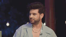 a man with a beard is wearing a necklace