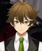 a young boy with brown hair and green eyes is wearing a suit and tie
