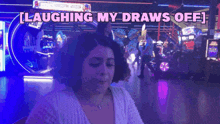 a woman is laughing while playing an arcade game