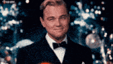 a man in a tuxedo and bow tie is smiling with rd btc in the corner