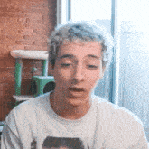a young man wearing a white t-shirt with a picture of a man on it