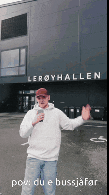 a man is standing in front of a building that says leroyhallen