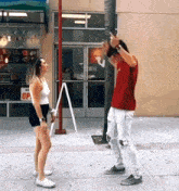 a man and a woman are standing on a sidewalk in front of berry 's