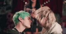 a man with green hair is looking at another man