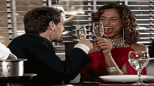 a man and a woman are toasting with wine glasses in a restaurant