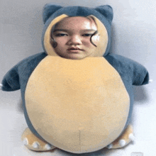 a stuffed animal with a woman 's face on it is sitting on a table .