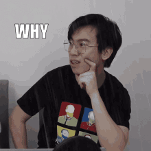 a man wearing glasses and a t-shirt that says why on it