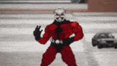 a pixel art drawing of ant man standing in front of a car