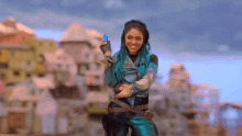 a woman with blue hair is standing in front of a city holding a blue object in her hand .