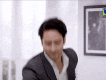a man in a suit is dancing in front of a picture that says sony pictures