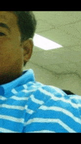 a man in a blue and white striped shirt is looking at the camera