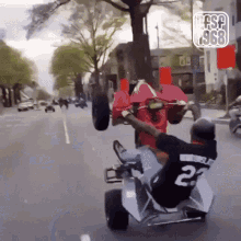 a man wearing a number 23 jersey is riding a three wheeled vehicle