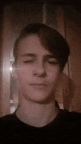 a young man with his eyes closed is standing in front of a mirror .